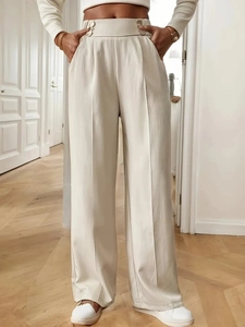Detail of high waisted wide leg trousers in beige with premium draped fabric and pleats