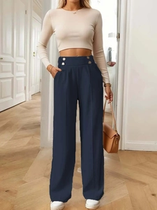 Detail of high waist trousers showing side metal button and crisp vertical front seam