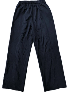 Detailed macro view of the high elastic waistband on loose black wide-leg trousers