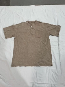Detail of men's brown short sleeve Henley shirt with buttoned collar and front pocket