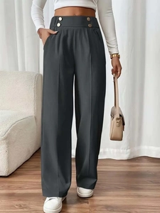 Detail of dark grey high waisted wide leg trousers with decorative gold buttons on waist