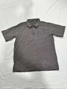 Detail of charcoal grey washed cotton polo shirt featuring half-zip collar and chest pocket