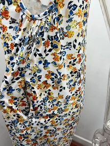 Detail der floral bedruckten Jumpsuit mit orangen Blumenmustern und Falten-Ausschnitt