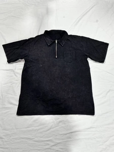 Close-up of black washed cotton polo shirt with half-zip collar and chest pocket detail