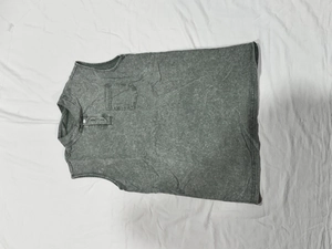 Dettaglio di polo da uomo senza maniche grigia con colletto henley e taschino sul petto
