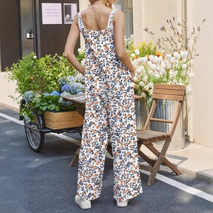 Ärmelloser Blumen-Jumpsuit mit verstellbaren Trägern und weitem Bein in sonniger Umgebung