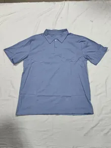 Détail d'un polo en coton bleu clair avec col classique et poche sur la poitrine