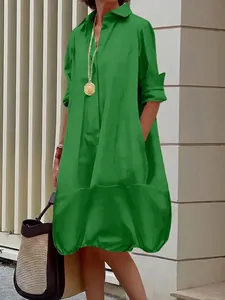 Detail view of grass green shirt dress featuring button-down front and side pockets