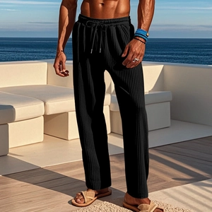 Detail of men's black ribbed trousers with drawstring waist in a casual resort setting