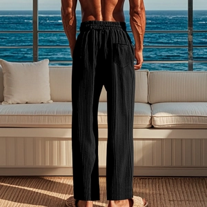 Rear view of men's black pleated trousers featuring an elastic waist and back patch pocket
