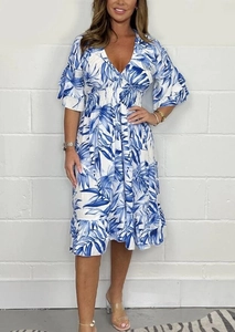 Close-up of tropical palm leaf print and smocked high waist detail on summer dress