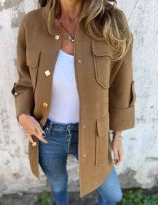 Detail of tan utility jacket featuring gold snap buttons and four functional patch pockets