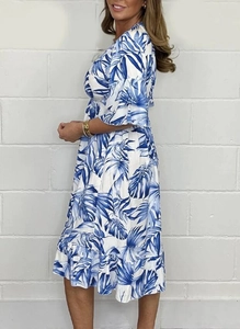 Detail view of high-waist summer dress with blue palm leaf print and tiered ruffle hem