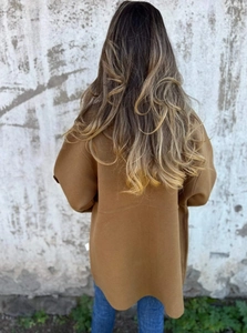 Rear view of long tan wool coat featuring a loose fit and stylish drop-shoulder design