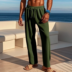 Detail of dark green ribbed pants showing textured fabric and drawstring waist