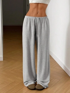 Detail view of grey wide-leg joggers featuring a flexible drawstring waistband and knit fabric