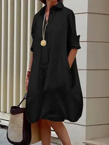 Detail of the elegant black long sleeve button-up dress with a flared silhouette