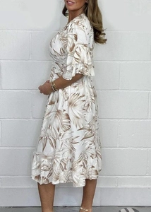 Detail of summer vacation dress featuring brown palm leaf prints and layered ruffle hem