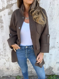 Close-up of deep brown wool-blend jacket with utility flap pockets and button collar