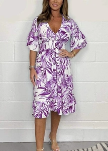 Detail of V-neck white dress with purple tropical leaf print and elastic smocked waist