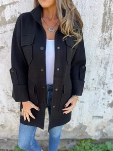Detail of black wool-blend shirt jacket featuring four flap pockets and round button closure