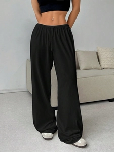 Detail of women's black high-waisted wide-leg sweatpants with adjustable drawstring waistband