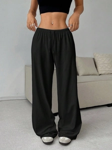 Detail of high-waist elastic waistband with adjustable drawstring on black sports pants