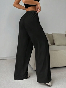 Detail view of high-waist black wide-leg joggers with elastic drawstring and side fit