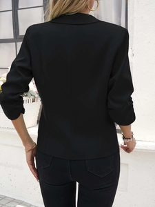 Detailansicht der schmalen Passform und der taillierten Nähte am schwarzen Blazer