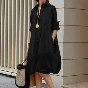 Elegant black long-sleeve button-down shirt dress with a relaxed silhouette and classic collar