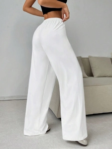 Detail view of white wide-leg drawstring sports trousers featuring elastic high waistband