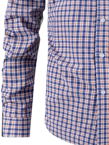 Close-up of orange and blue plaid shirt featuring woven fabric texture and buttoned cuffs