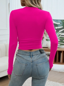 Detail of rose red long sleeve crop top featuring ruched back design and slim fit material