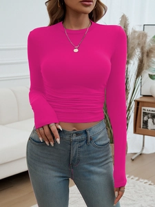 Detail of slim fit magenta crop top featuring long sleeves and pleated waist design