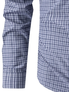 Close-up of blue and white plaid shirt showing precise cuff stitching and fabric texture