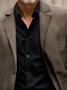 Detail of dark brown plaid blazer with notch lapel and premium textured fabric