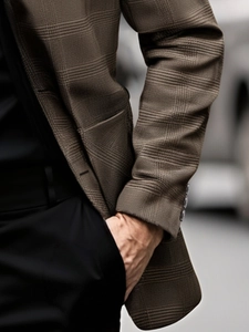 Detail of premium brown plaid blazer sleeve showing fine fabric texture and cuff buttons
