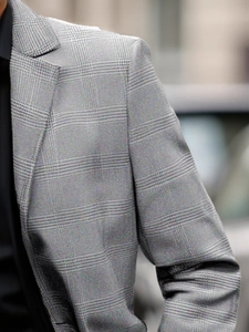 Detail of grey Prince of Wales check blazer showing notch lapel and shoulder texture