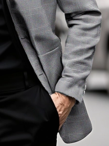 Close-up of grey plaid suit jacket sleeve featuring four decorative buttons and fabric texture