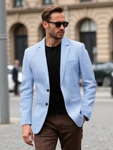Detail of light blue linen blazer texture with classic notched lapel and button detail