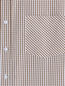 Detail of brown and white gingham shirt featuring diagonal pocket and white buttons