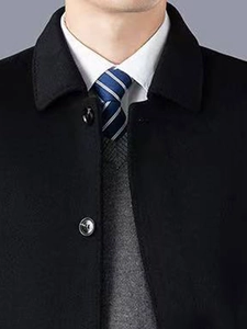 Détail d'un manteau en laine noir avec revers et ensemble business classique