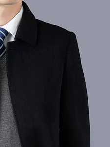 Détail du revers d'un manteau en laine noir pour homme avec chemise et cravate