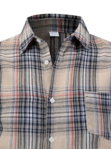 Detailed close-up of khaki plaid flannel shirt fabric with chest pocket and white buttons