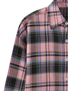 Close-up of flannel plaid shirt fabric showing colorful weave and white button detail