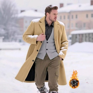 Men's stylish long single-breasted wool overcoat in camel standing in snowy urban street