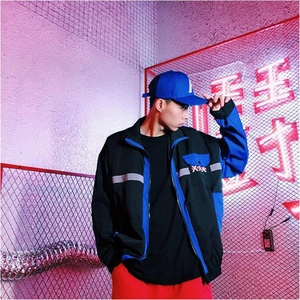 Detail of men's color-block jacket with reflective stripes and streetwear embroidery