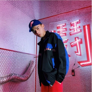 Close-up of street style patchwork jacket with zipper and elastic cuffs in neon lighting