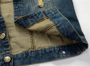 Close-up of distressed denim vest with bronze buttons and vintage washed texture