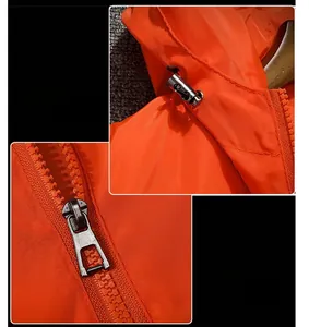 Detail der orangefarbenen Kapuzenjacke mit Harzreißverschluss und Kordelzug aus Metall